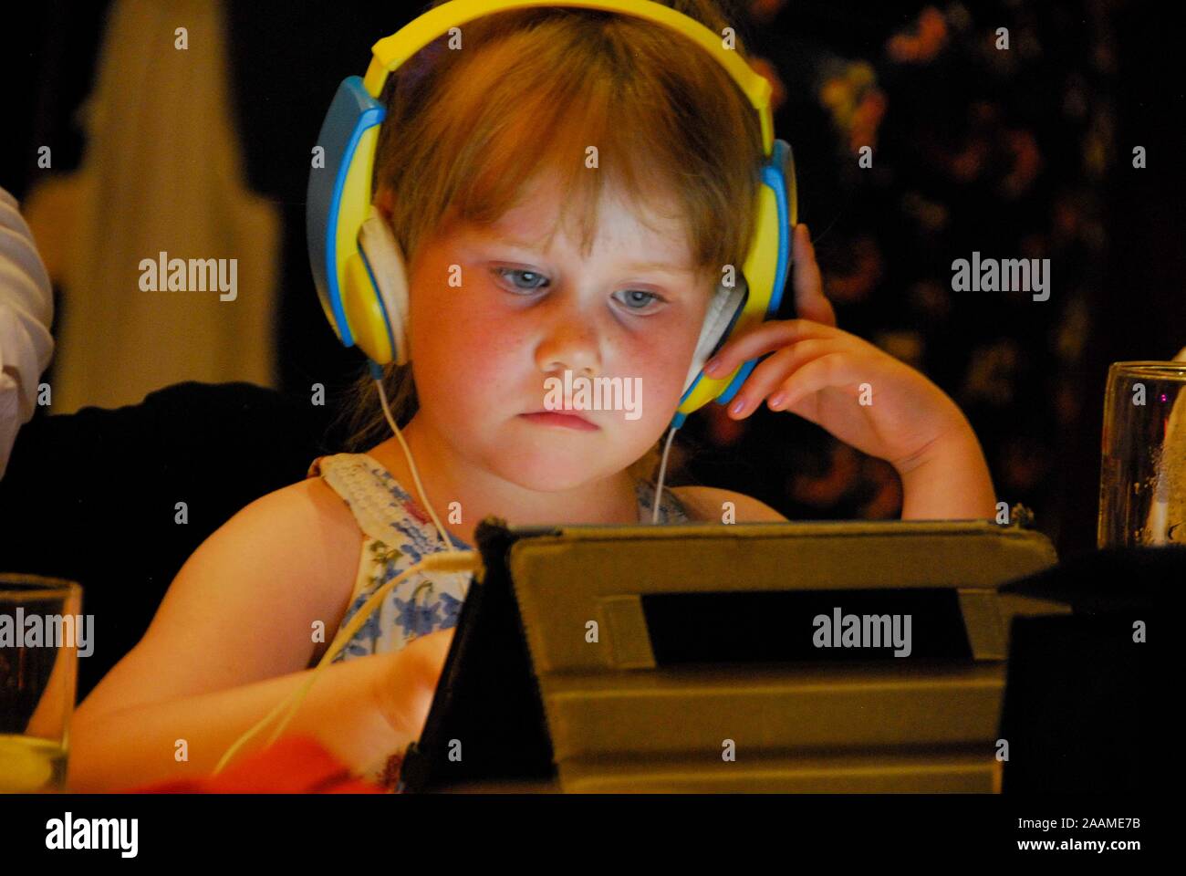 Ein sehr junges Kind Kopfhörer tragen und mit dem Ipad. Stockfoto