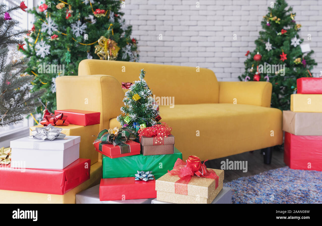 Weihnachten Wohnzimmer, Gelb Sofa mit Weihnachtsbäumen, Geschenkboxen, und Weihnachtsschmuck Stockfoto