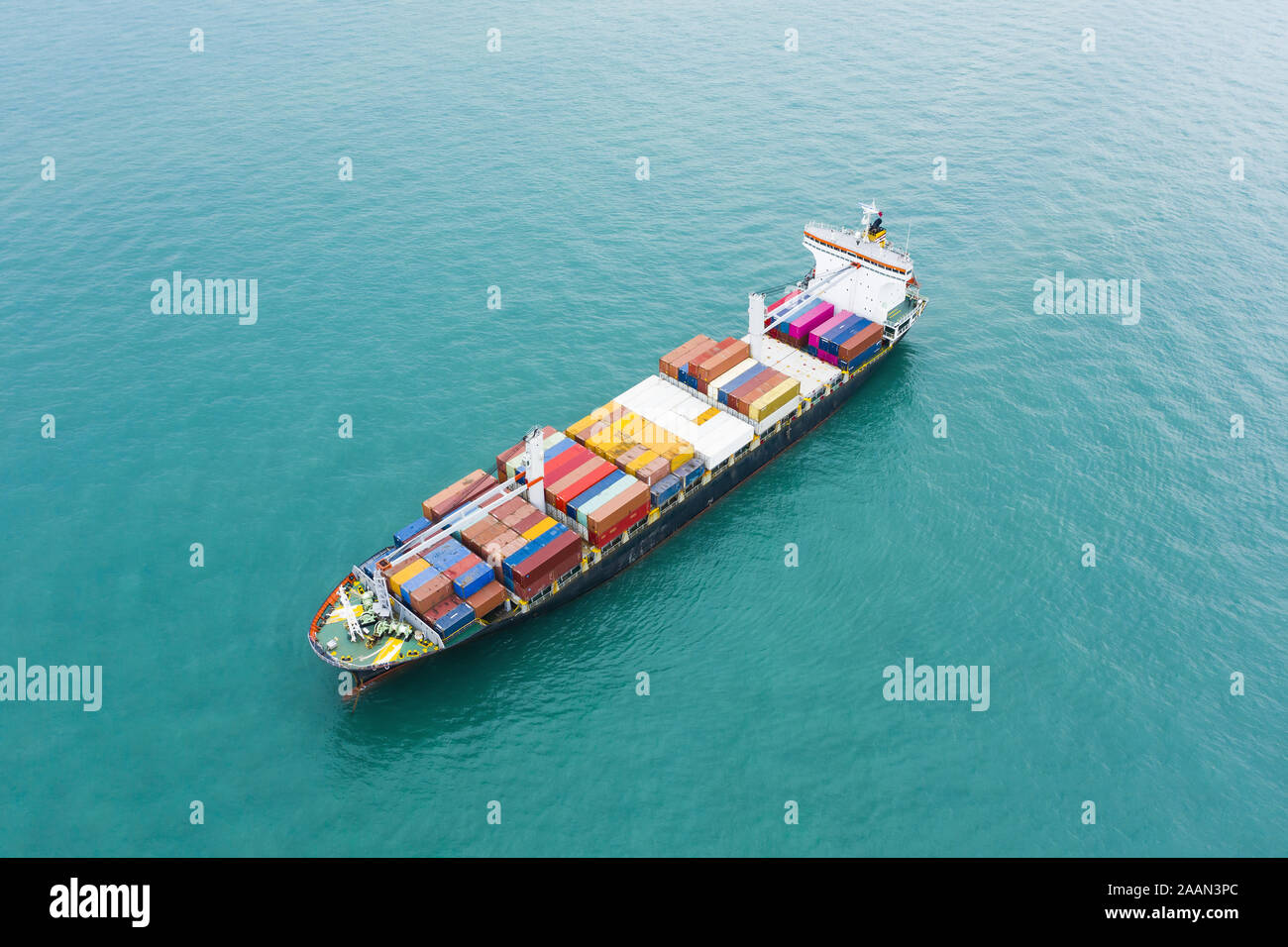 Ansicht von oben, atemberaubenden Blick auf ein Schiff segeln mit Hunderten von farbigen Behälter direkt in den Hafen von Singapur. Stockfoto