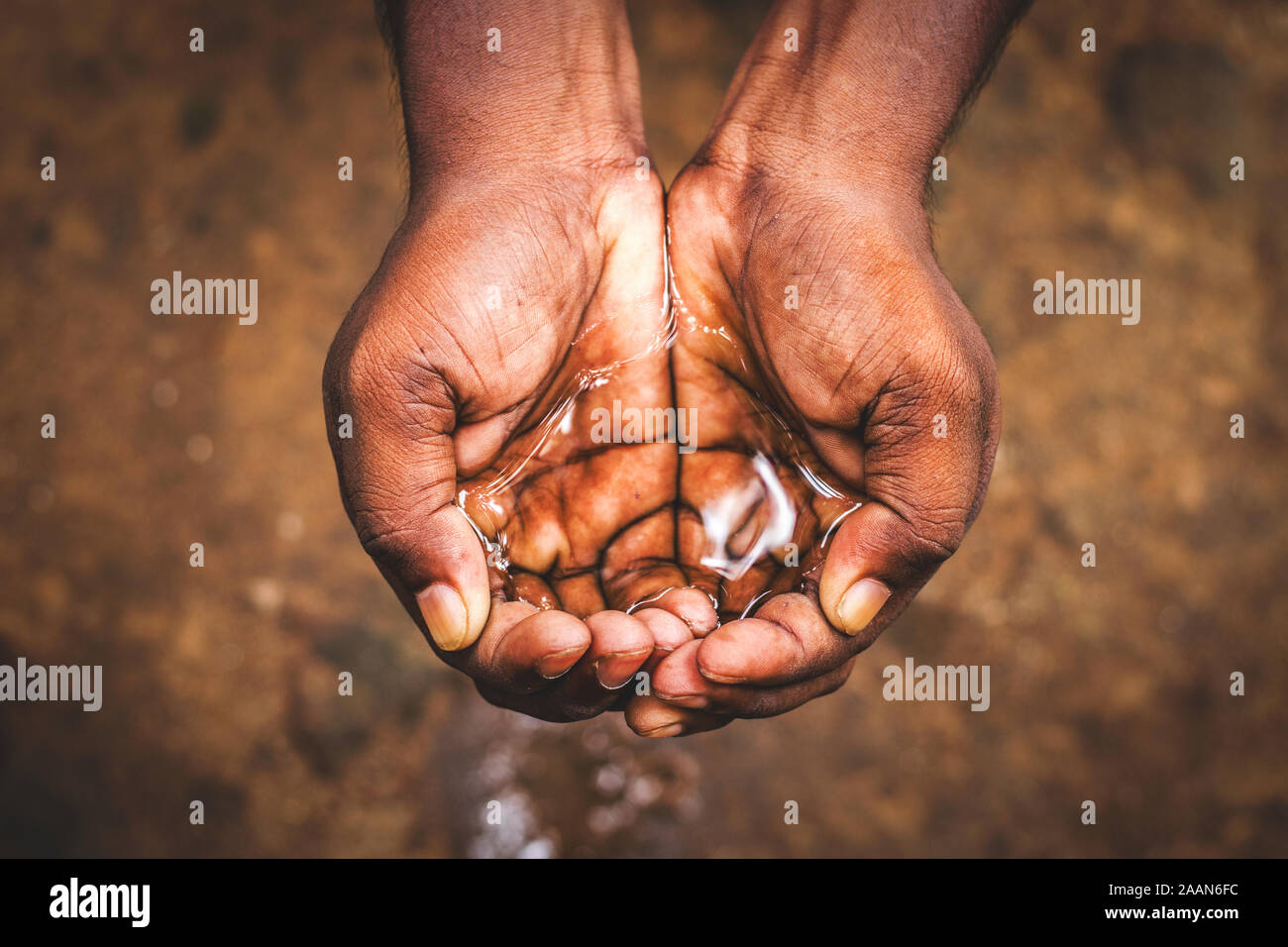 Ein Mann hält Wasser mit seiner Hand, Wasserkrise in Indien und weltweit Stockfoto