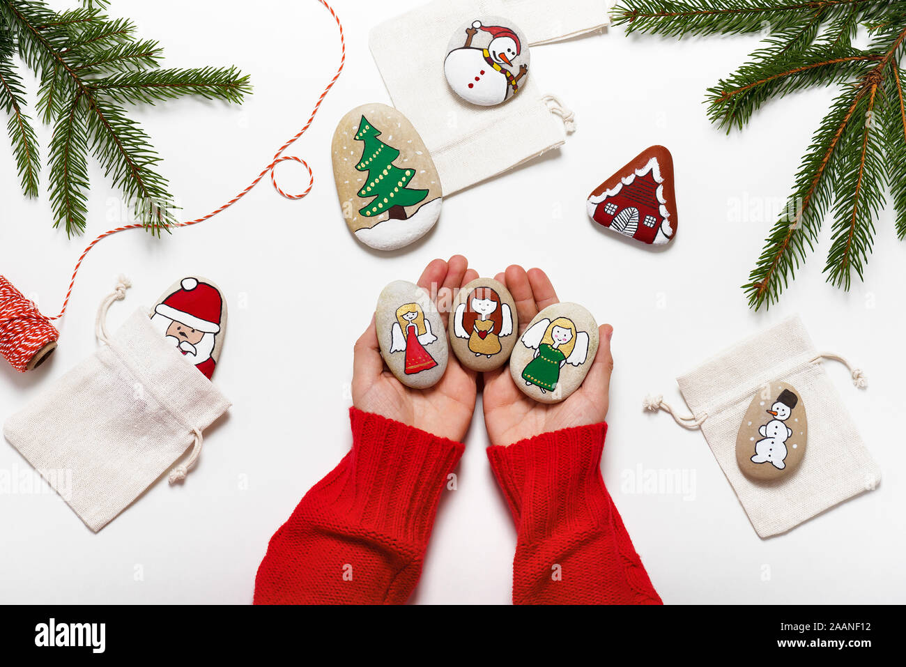 Wunderschöne handbemalte Steine mit Engel Motiv halten durch die Hände. Einfach Spaß Kinder Kunsthandwerk Konzept. Stockfoto