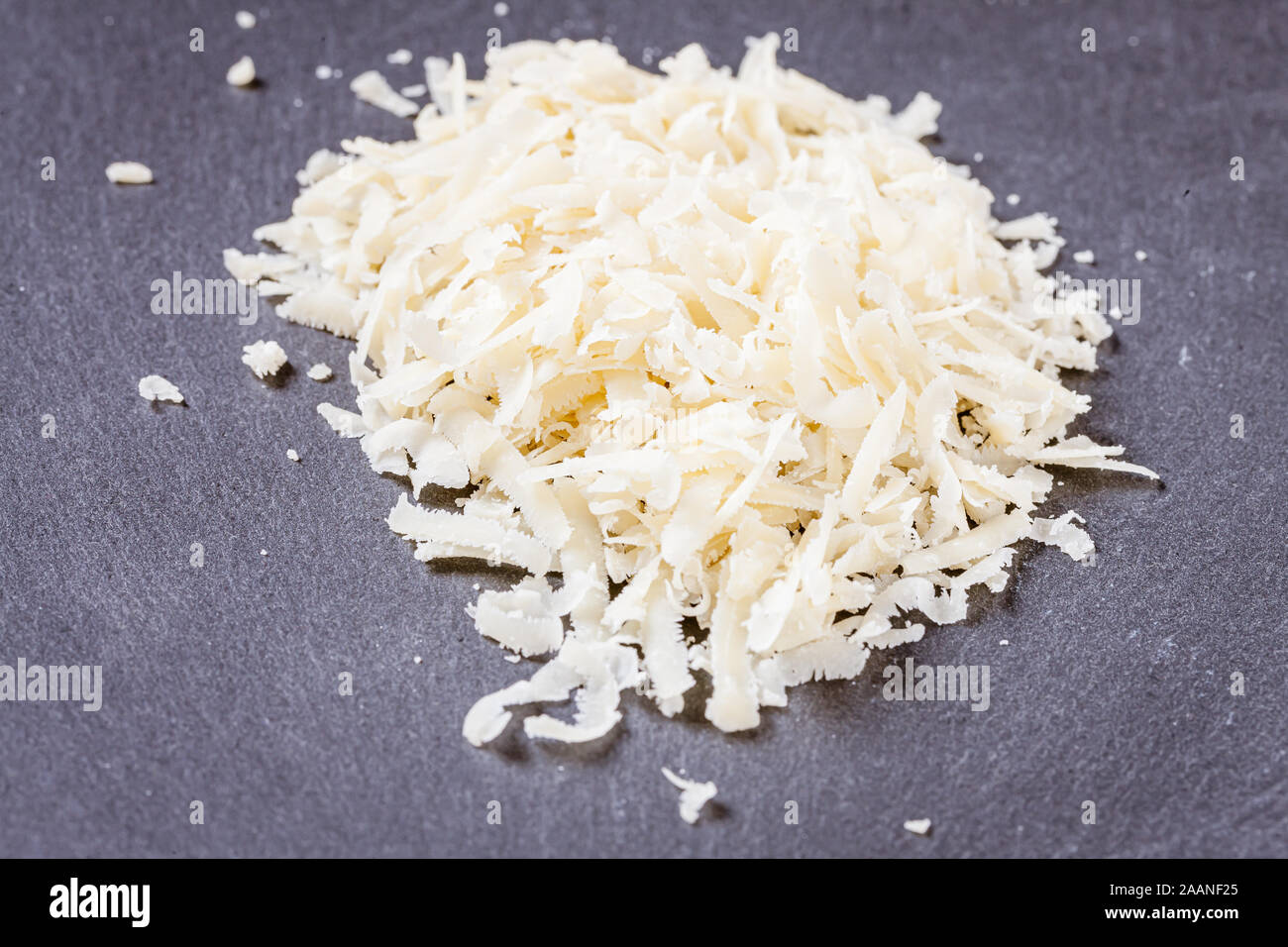 Geriebenen Parmesan, Schiefer Hintergrund Stockfoto