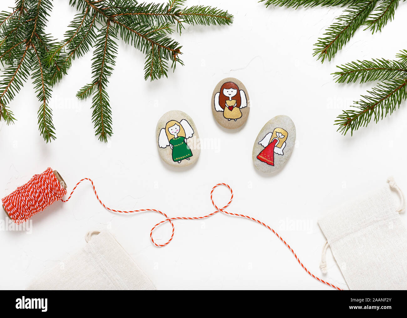 Steine mit weihnachtlichen Motiven wie Engeln verziert. Ansicht von oben. Stockfoto