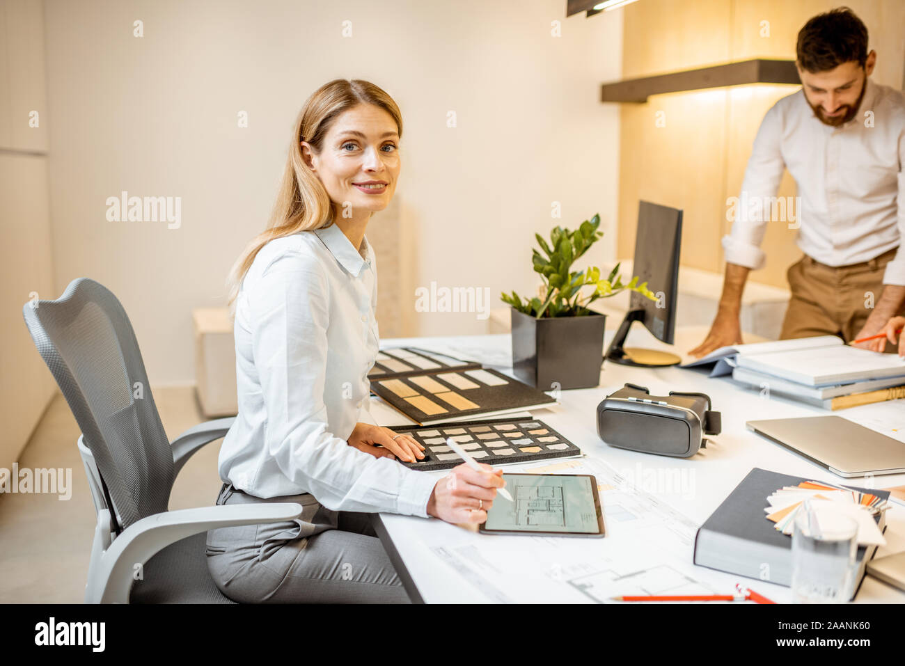 Porträt einer schönen Frau, dabei einige kreative Arbeit am großen Tisch mit Kollegen im Büro. Konzept eines architektonischen Business und kreatives Arbeiten Stockfoto