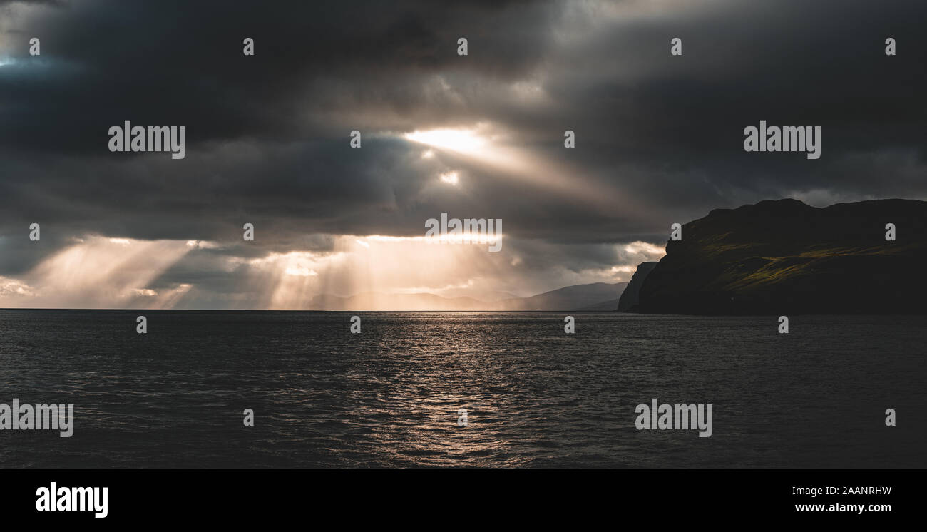 Schöne Sonnenstrahlen brechen durch die Wolken in Sandoy und Hestur Fähre reisen, Färöer Inseln Stockfoto