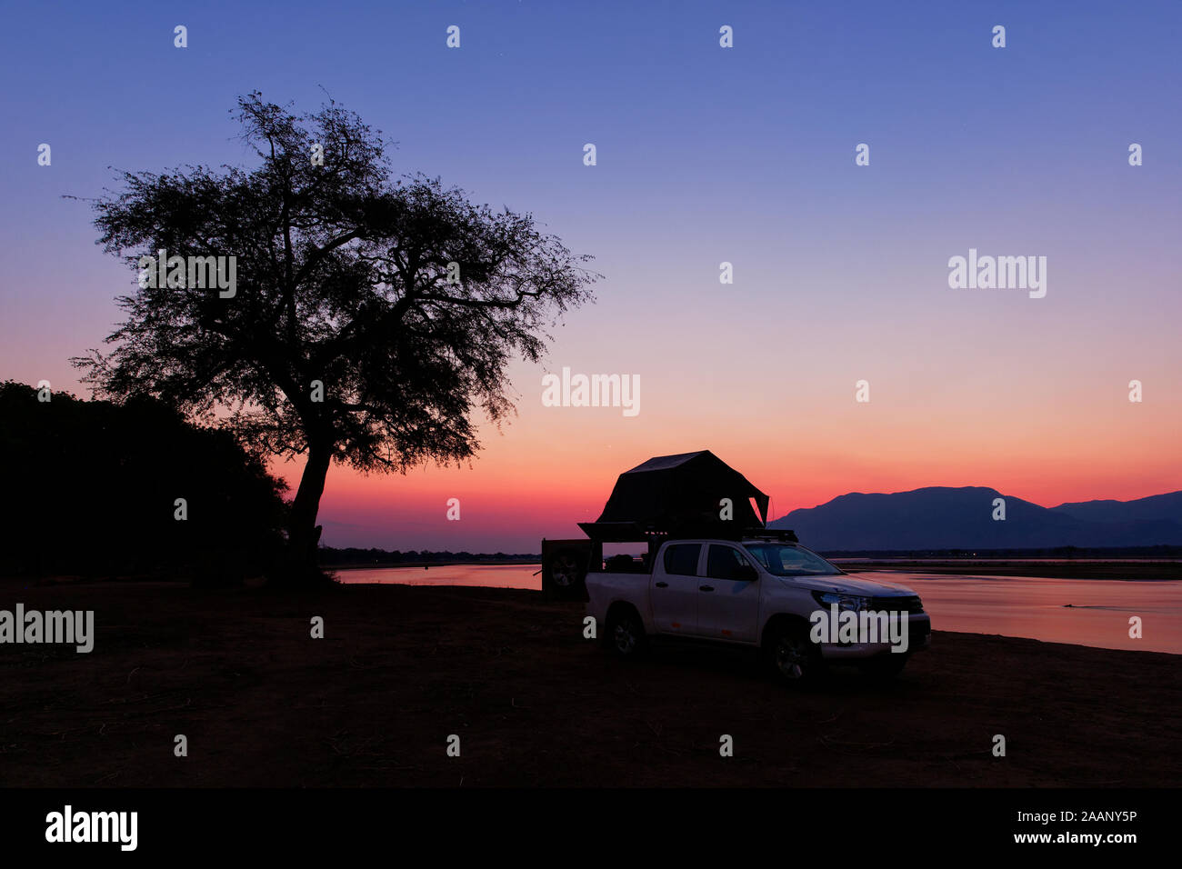 Safari im eigenen Pkw mit Zelt auf dem Dach, am Ufer des Sambesi in Simbabwe schlafen, Stern am Himmel und Nacht Bild. Stockfoto