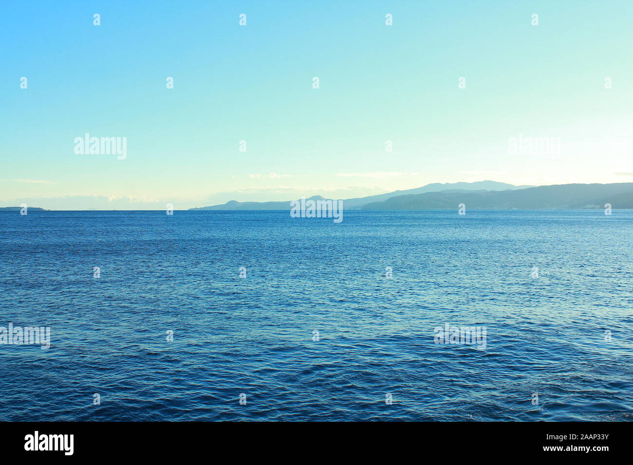 Blue Ocean und blauer Himmel. öffnen, ruhiges Meer Wasser. Horizontale, Ruhig, wunderschön, friedlich, ruhig, leer und ruhig. fernen Land, Berge und Inseln. Stockfoto