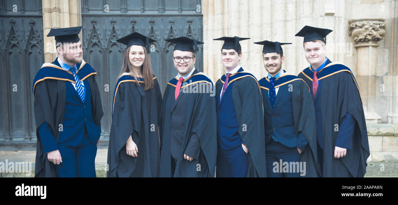 Eine Gruppe von Happy New York St John University Absolventen tragen Kleider und Hüte Mortarboard auf ihrer Abschlussfeier an der York Minster Stockfoto