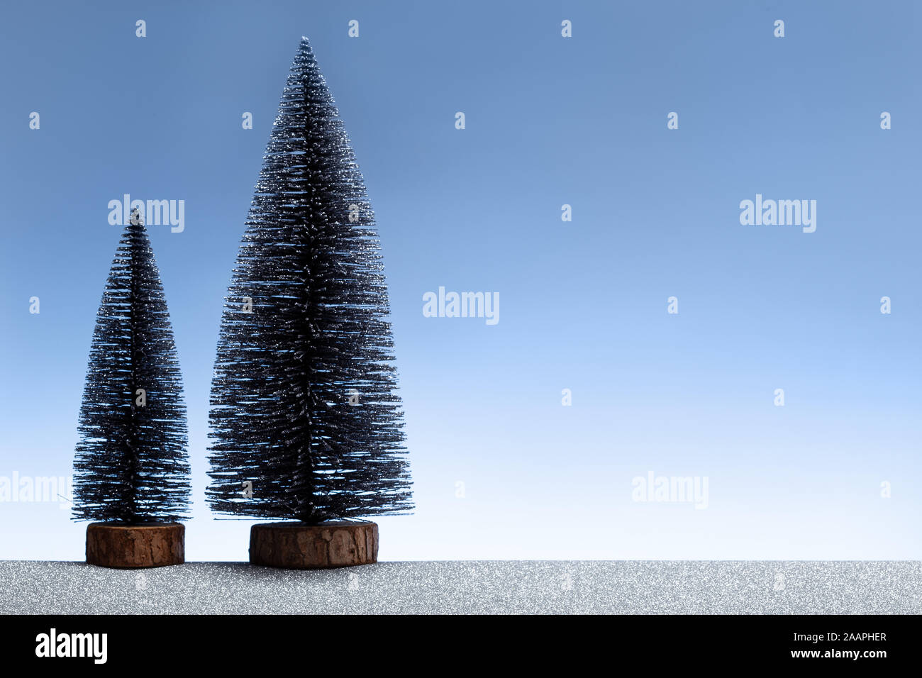Weihnachten Hintergrund. Minimalistische Szene mit Miniatur Tannen und funkelnden silbernen und blauen Himmel. Platz kopieren Stockfoto