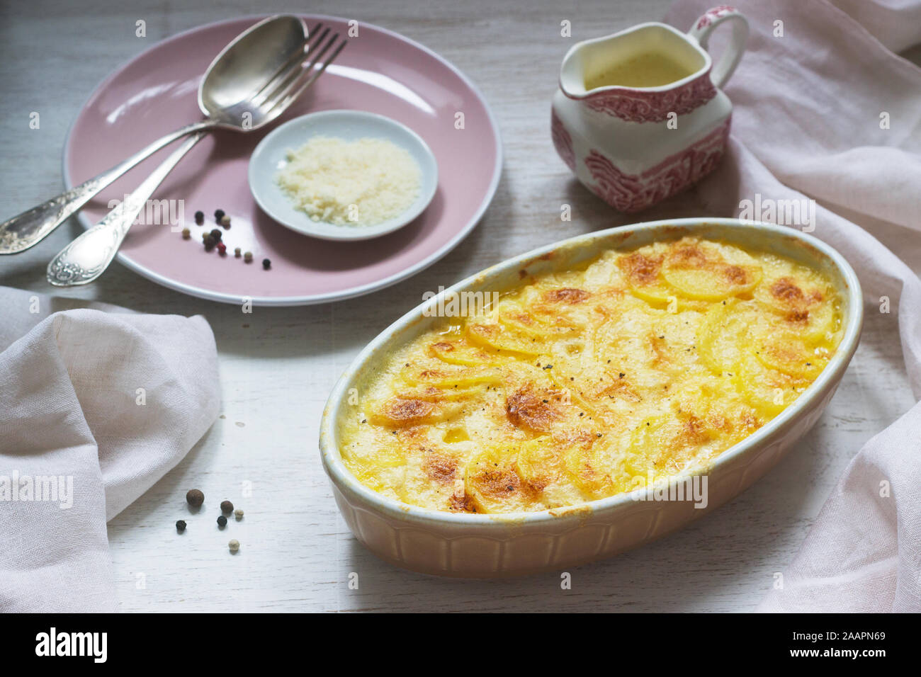 Französische Gericht Gratin Dauphinois in keramischen Form auf einem hellen Hintergrund. Im rustikalen Stil. Stockfoto