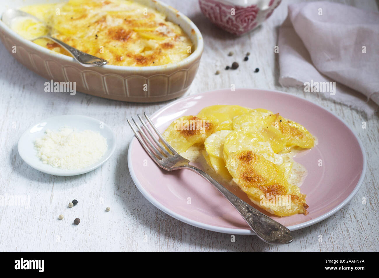 Französische Gericht Gratin Dauphinois in keramischen Form auf einem hellen Hintergrund. Im rustikalen Stil. Stockfoto