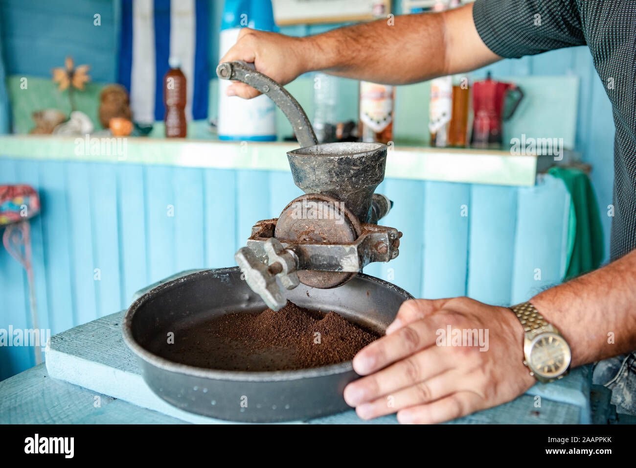 Kuba: Man mahlt mit einer alten Kaffeemühle Stockfoto