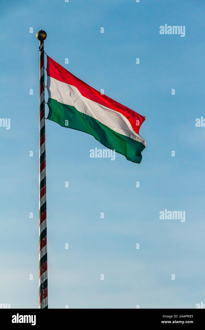 Ungarn, ungarische nationale Flagge schwenkten auf blauen Himmel Hintergrund Stockfoto