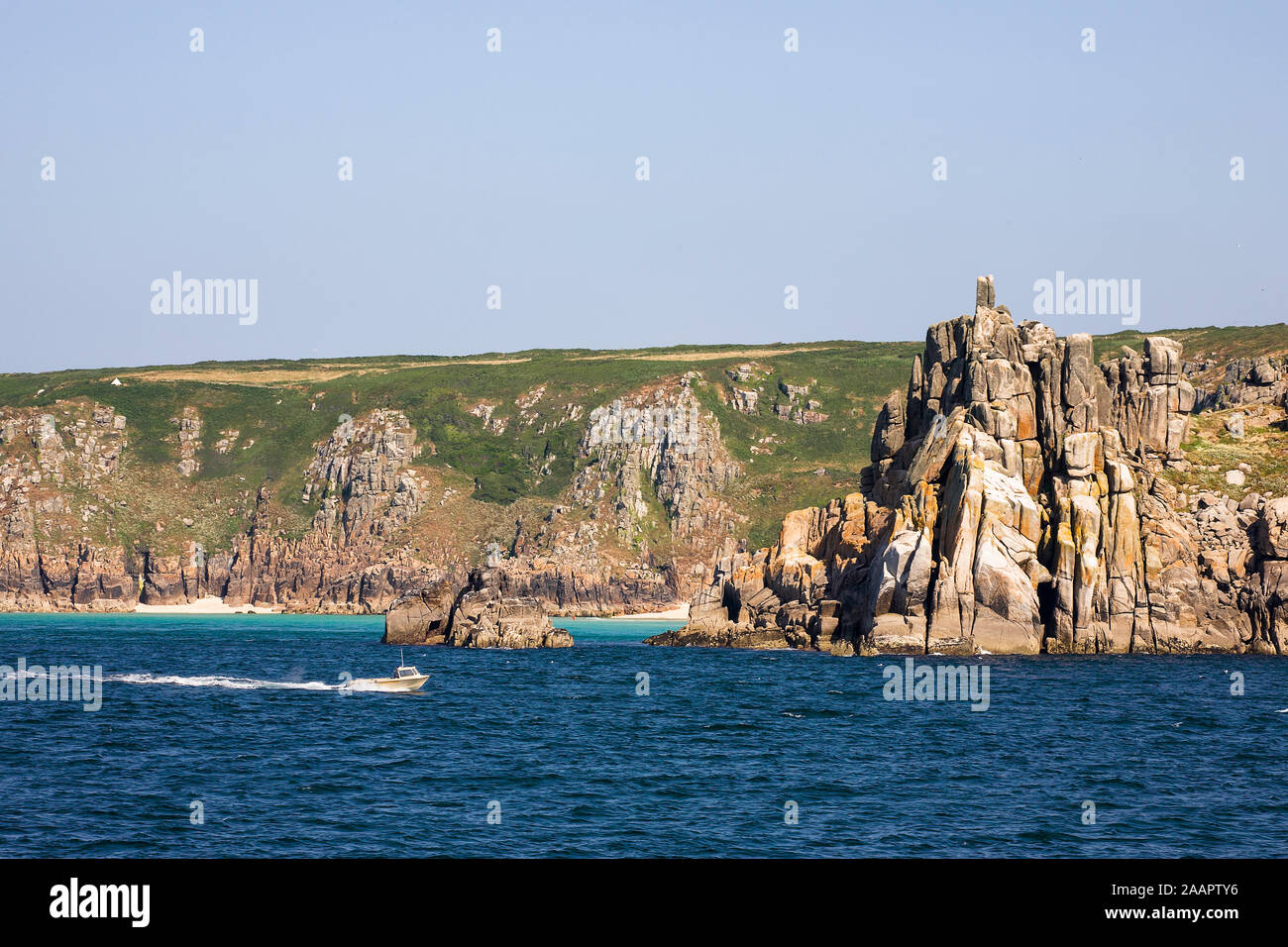 Teryn Dinas und Porthcurno Beach, West Penwith, Cornwall, UK von seewärts an einem ruhigen Sommer Stockfoto