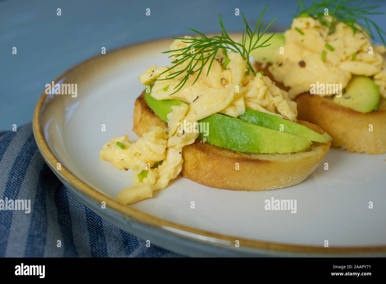 Essen Fotografie von Rührei und Avocado Toast auf einem blauen Hintergrund Stockfoto