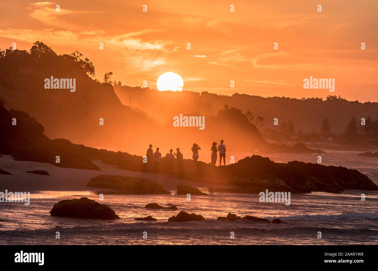 Freunde genießen Sie das Ende eines perfekten Tages, der Sonnenuntergang am Watago, Byron Bay, NSW Stockfoto