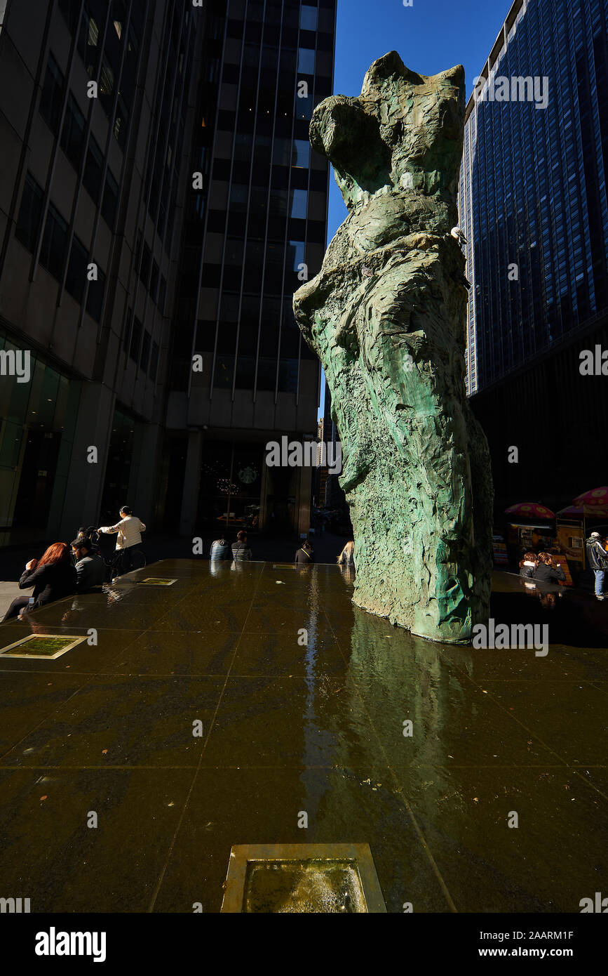 Blick auf den massiven Gebäuden in Midtown Manhattan - Jim Dine Skulpturen" in Richtung Avenue' Sixth Avenue an der West 53rd Street suchen Stockfoto