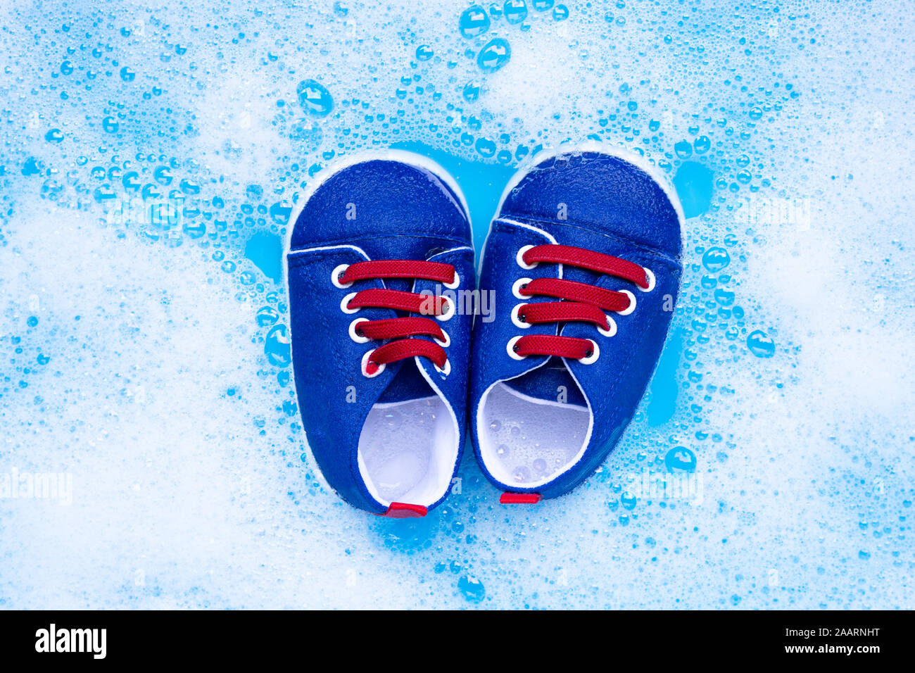 Genießen Sie Baby Schuhe Baby Waschmittel Wasser Auflösung vor dem Waschen. Wäscheservice Konzept, Ansicht von oben Stockfoto