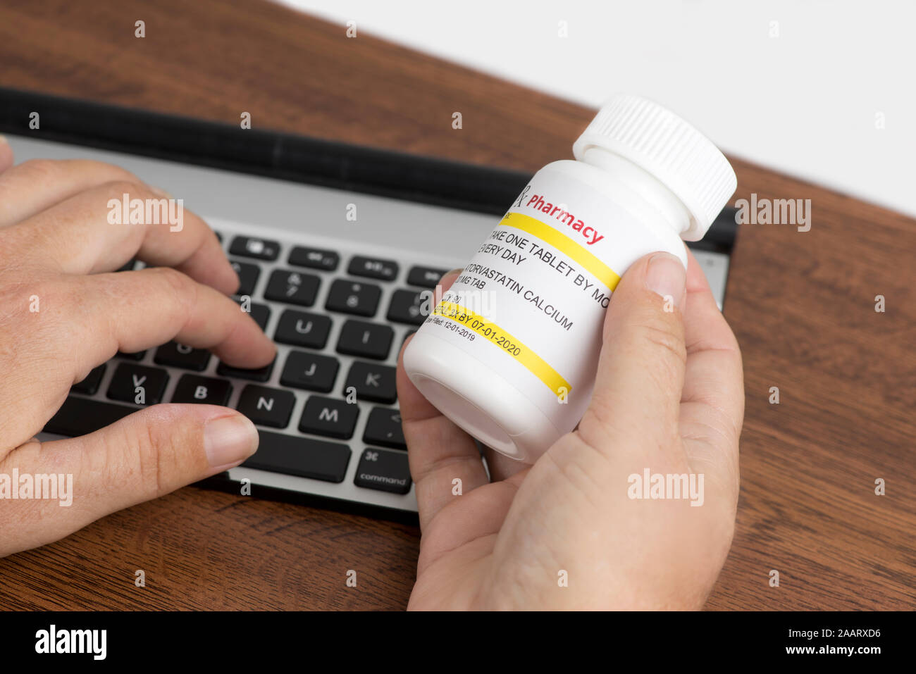 Patient sucht nach Informationen über Nebenwirkungen von verschreibungspflichtigen Medikamente mit persönlichen Computer zu Hause. Stockfoto