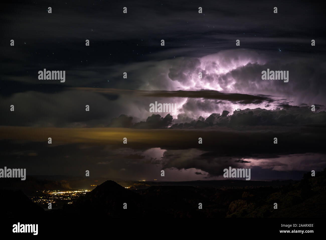 Große Abend Gewitter über kleine Wüste Stadt Moab Utah. Cloud Blitz zu Cloud beleuchtet die dunklen Nachthimmel mit Sternen sichtbar über dem t Stockfoto