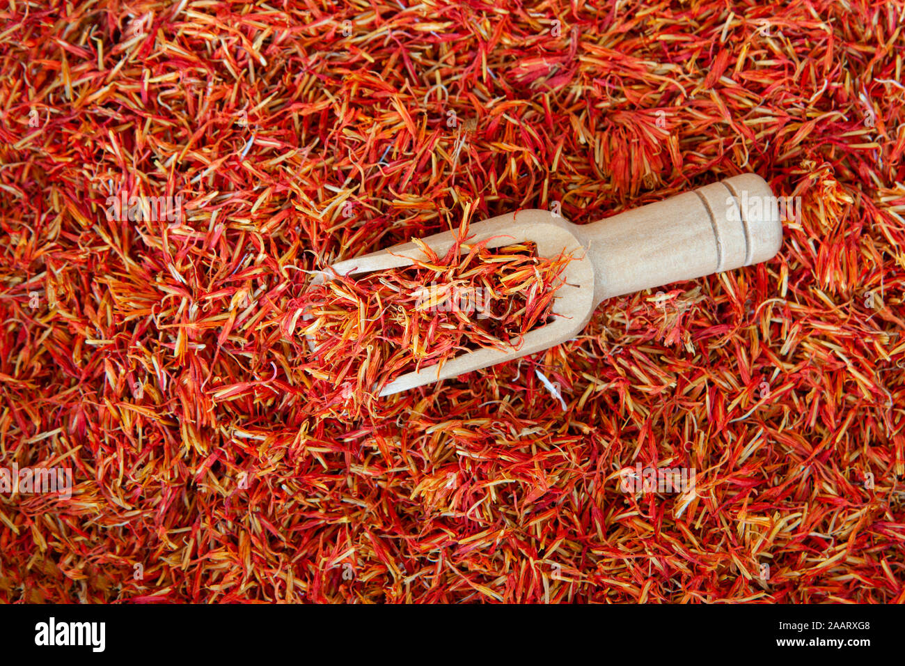 Viele würzige Safran Gewürz der ganze Hintergrund mit einem hölzernen Spice Spachtel Stockfoto