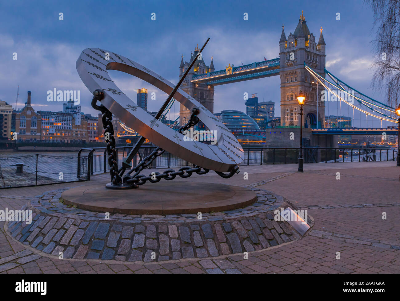 Blick auf die borduhr Sonnenuhr und die Tower Bridge über die Themse in London, Vereinigtes Königreich bei Sonnenuntergang an einem bewölkten Tag Stockfoto