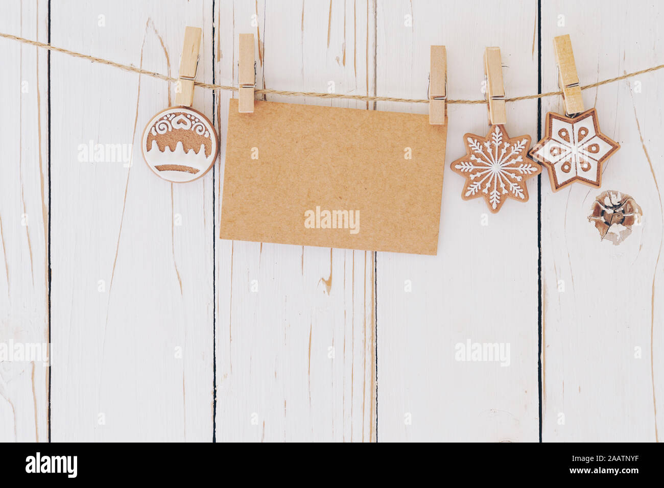 In der Nähe von Weihnachten Dekoration und leeres Papier Karte hängen auf Holz Hintergrund. Stockfoto