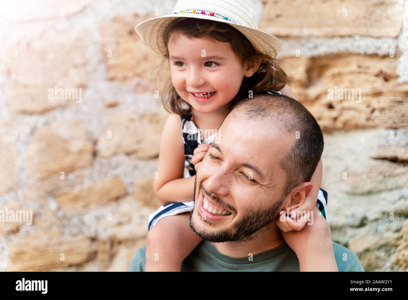 Portrait von glücklichen kleinen Mädchen auf den Schultern ihres Vaters Stockfoto