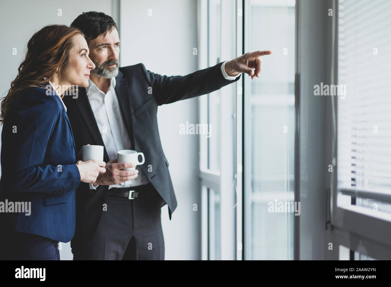 Unternehmerin und Unternehmer in Office Blick aus Fenster Stockfoto