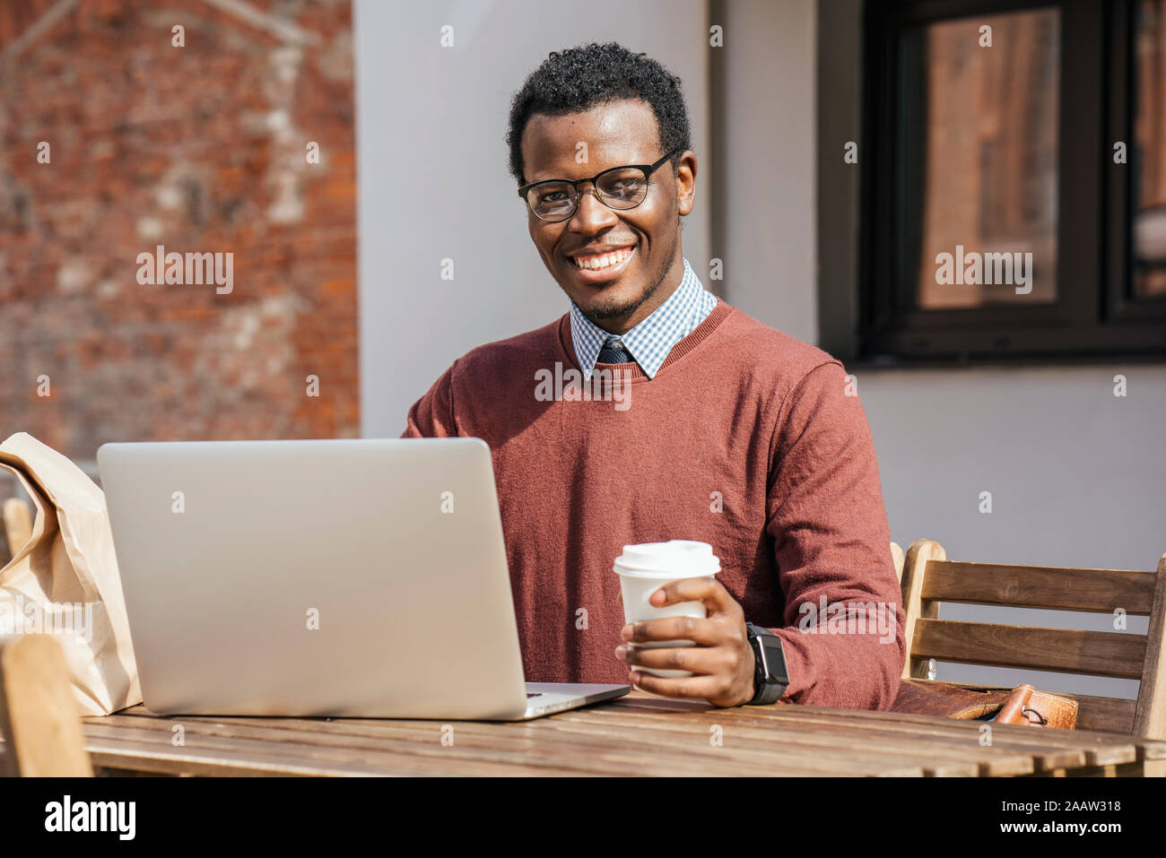 Junger Mann mit Laptop im Coffeeshop, Kaffee trinken Stockfoto