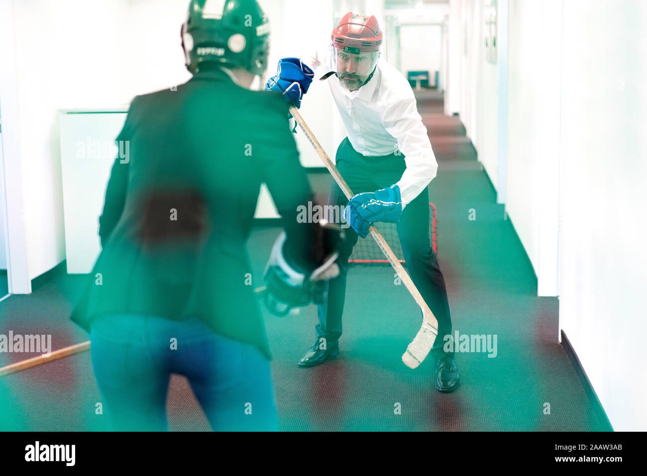 Business-frau und Geschäftsmann spielen Eishockey im Büro Stockfoto