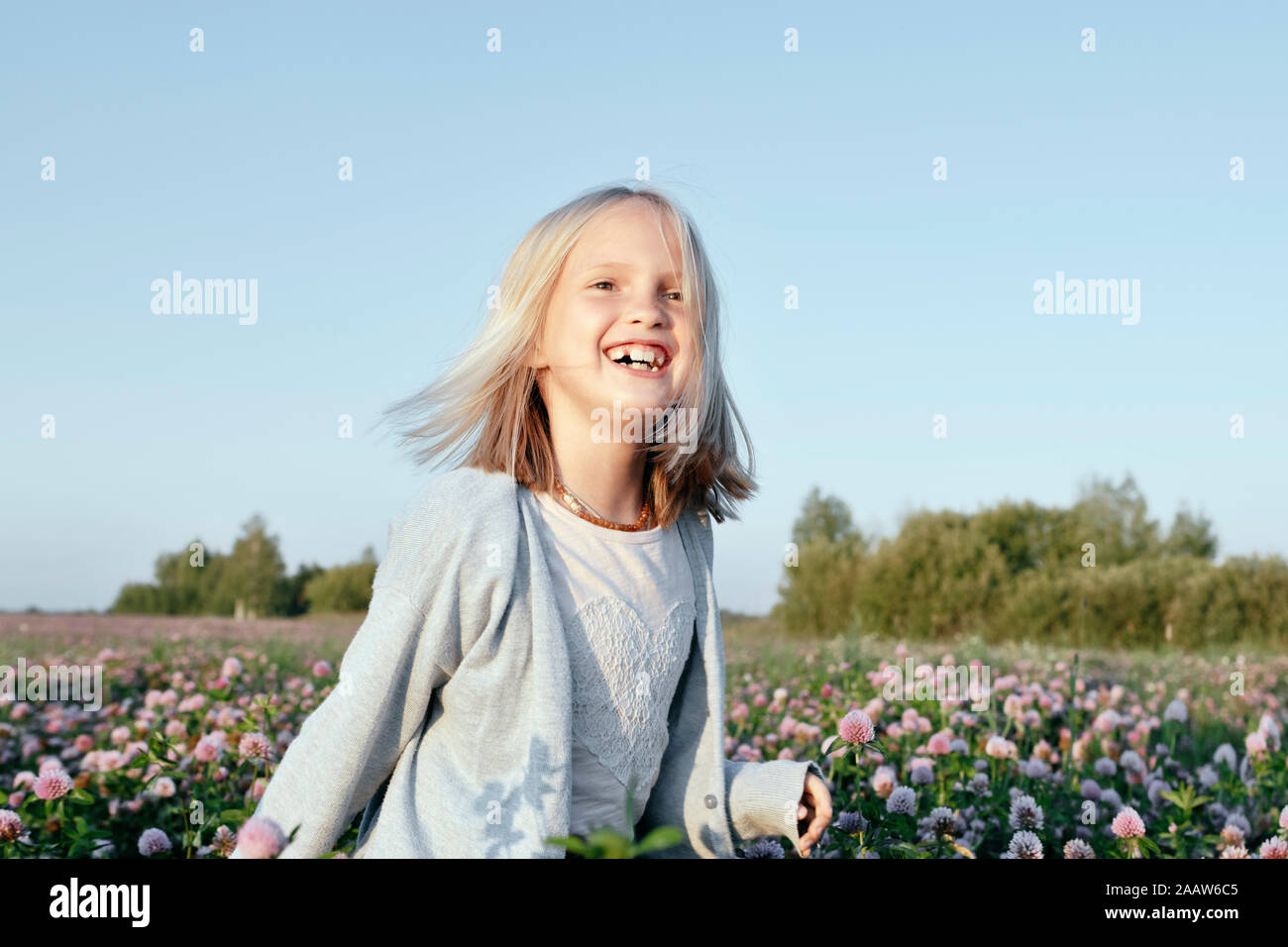 Porträt eines lächelnden Mädchen stehen auf einem Klee Feld Stockfoto