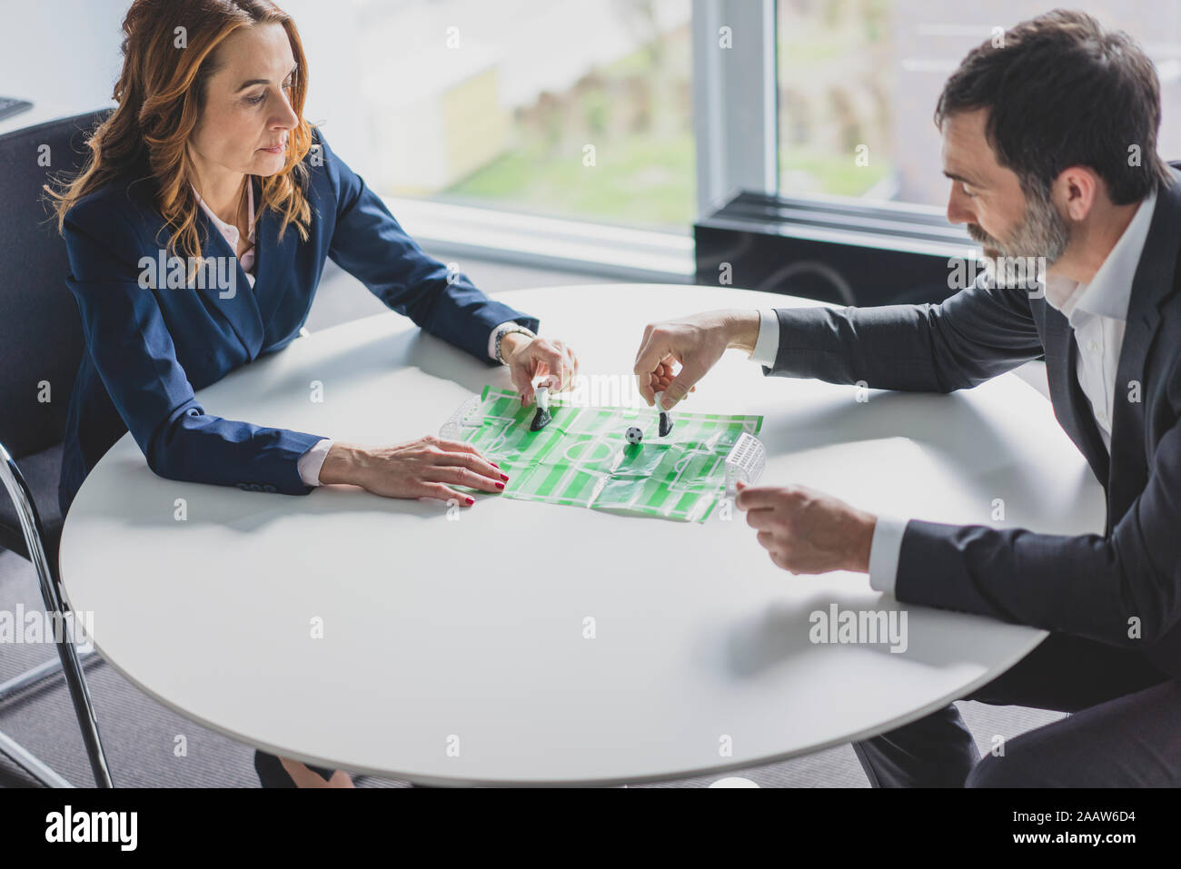 Business-frau und Geschäftsmann Spielen Tischfußball in Office Stockfoto