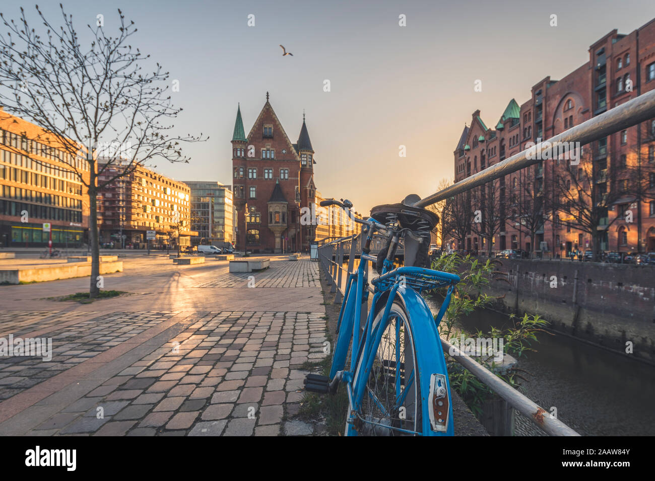 Fahrrad auf Fußweg gegen Speicherstadt bei Sonnenuntergang in Hamburg geparkt, Deutschland Stockfoto