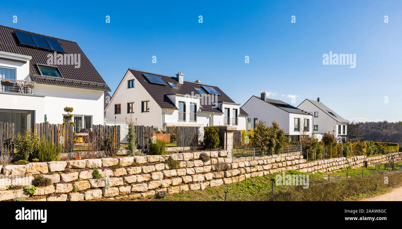 Häuser mit Solarzellen auf dem Dach gegen den klaren blauen Himmel, Baden-Württemberg, Deutschland Stockfoto