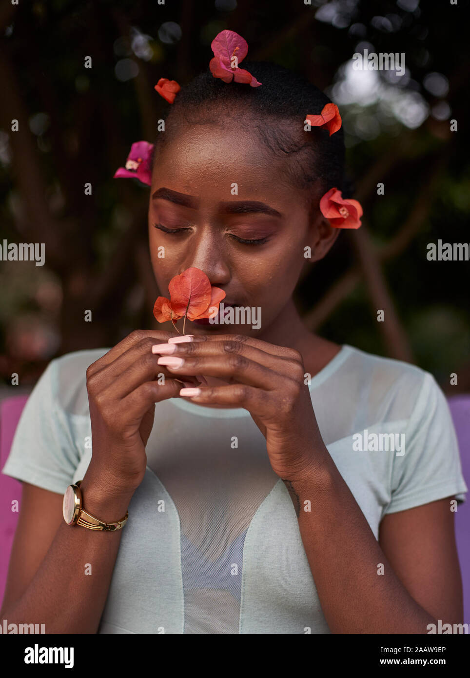Porträt der jungen Frau riechen eine Blume Stockfoto