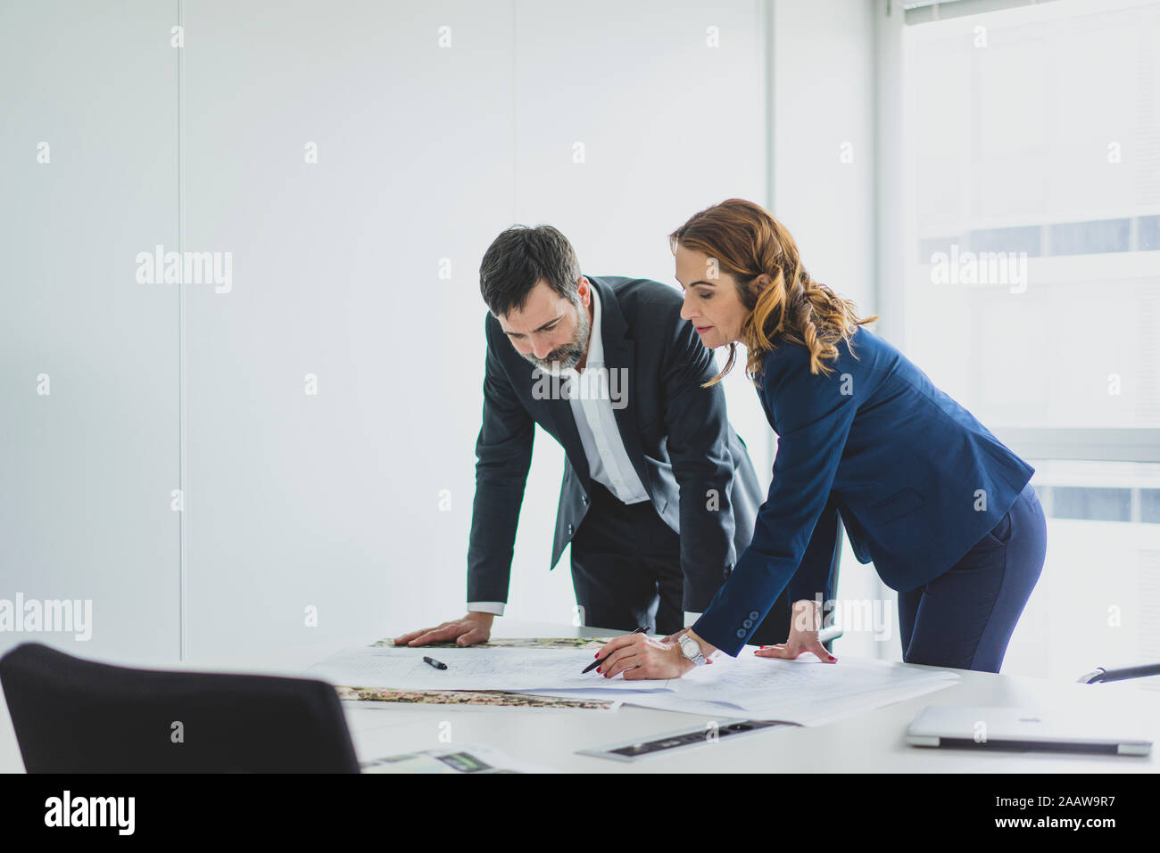 Unternehmerin und Unternehmer arbeiten am Plan auf dem Schreibtisch im Büro Stockfoto