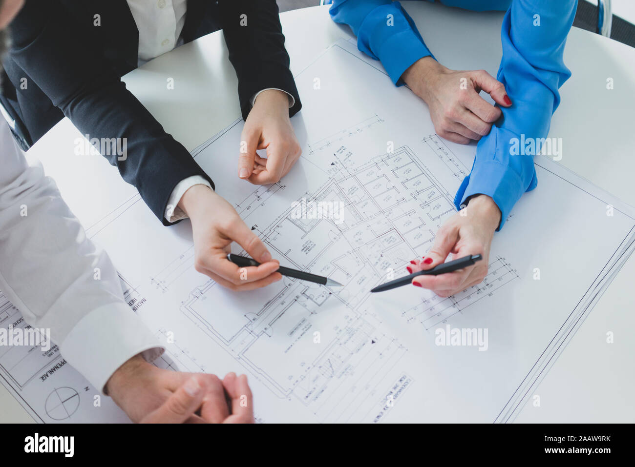 Nahaufnahme der Geschäftsmann und zwei Unternehmerinnen Arbeiten am Plan auf dem Schreibtisch im Büro Stockfoto
