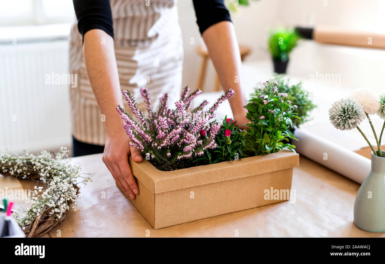 In der Nähe von Frau mit Blumen, der in einer Kartonage verpackt auf Tisch Stockfoto