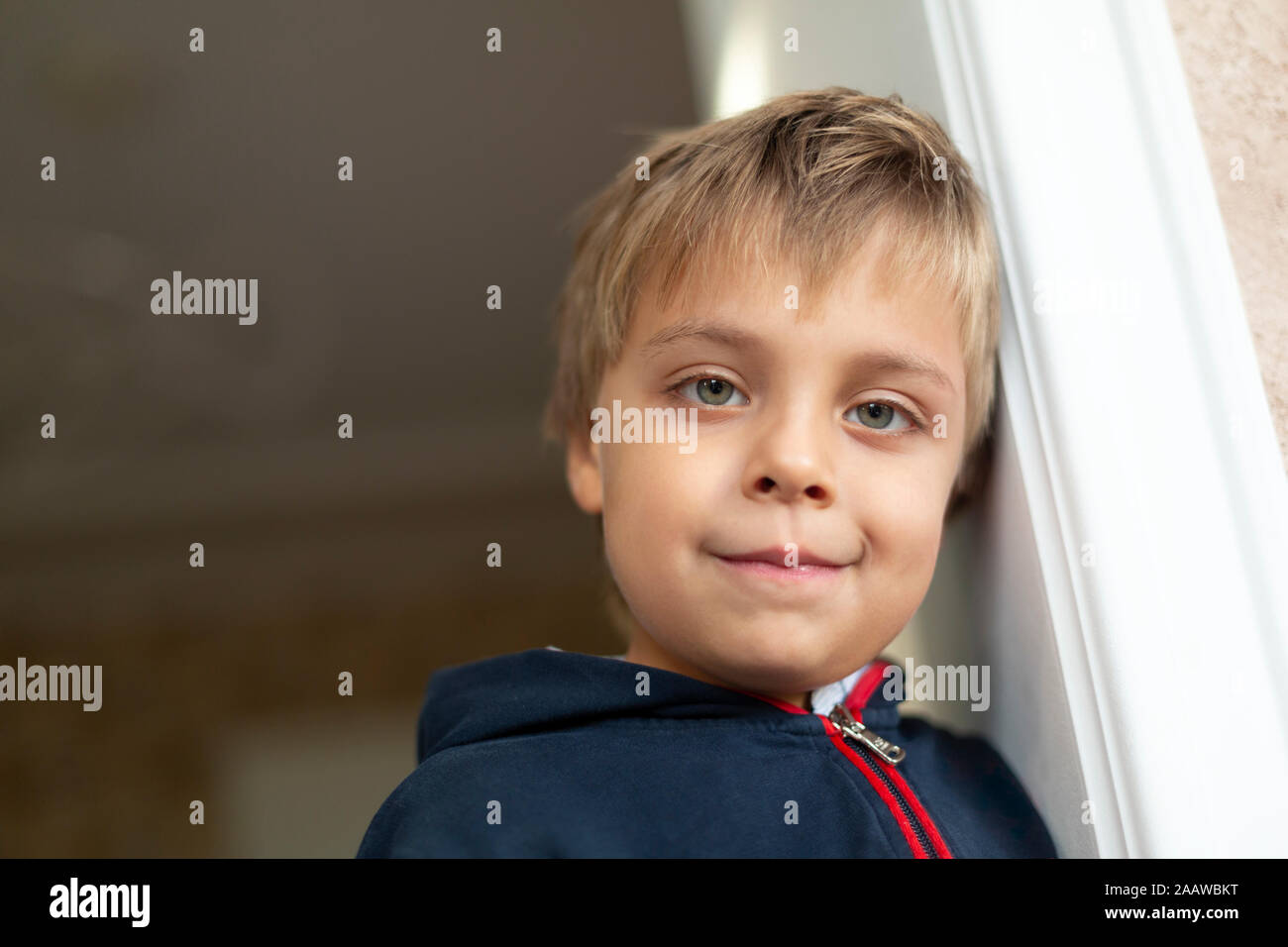 Portrait von kleinen Jungen gegen die Tür bei schiefen Stockfoto