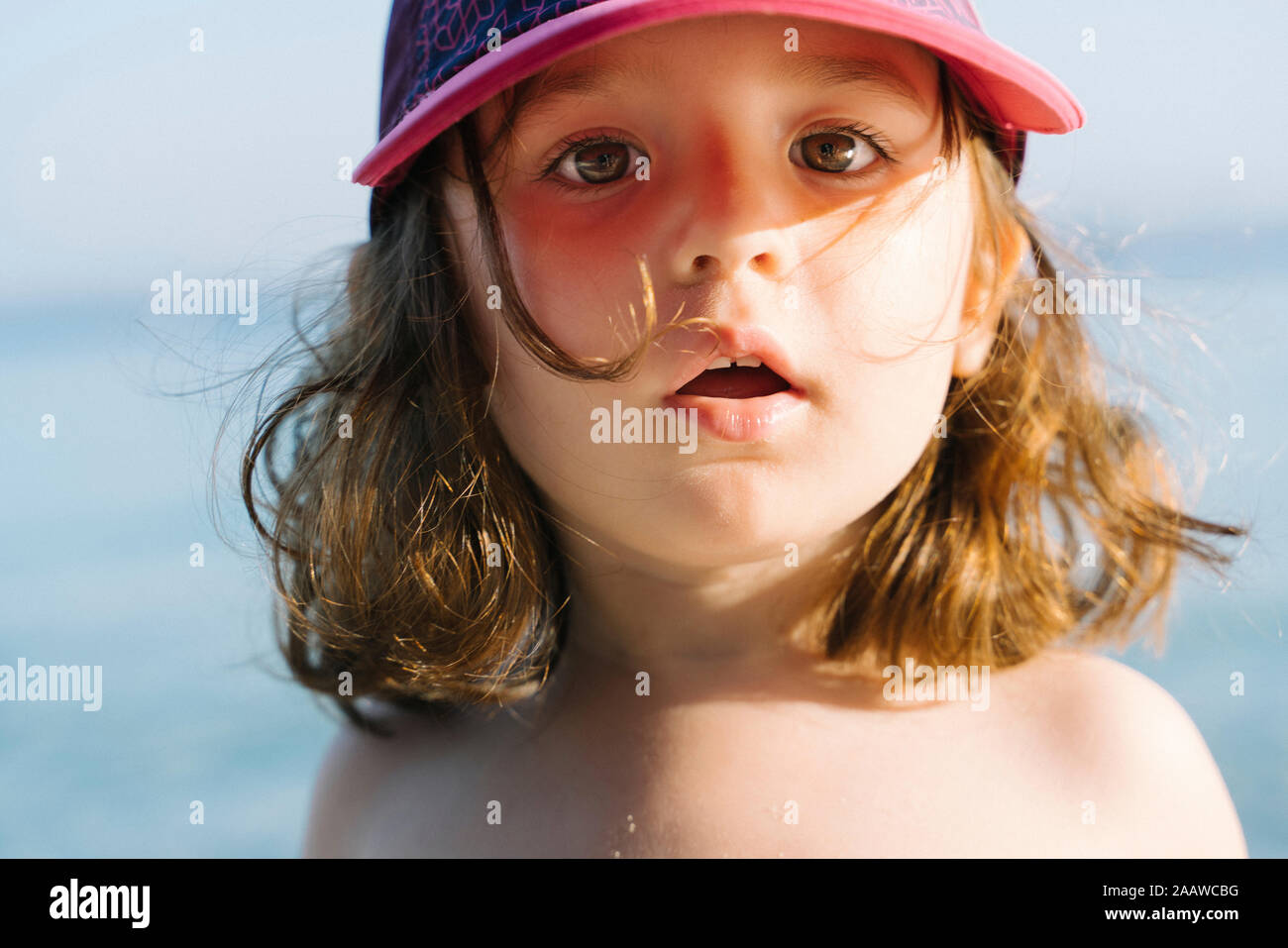 Portrait von kleinen Mädchen mit Kappe am Strand Stockfoto