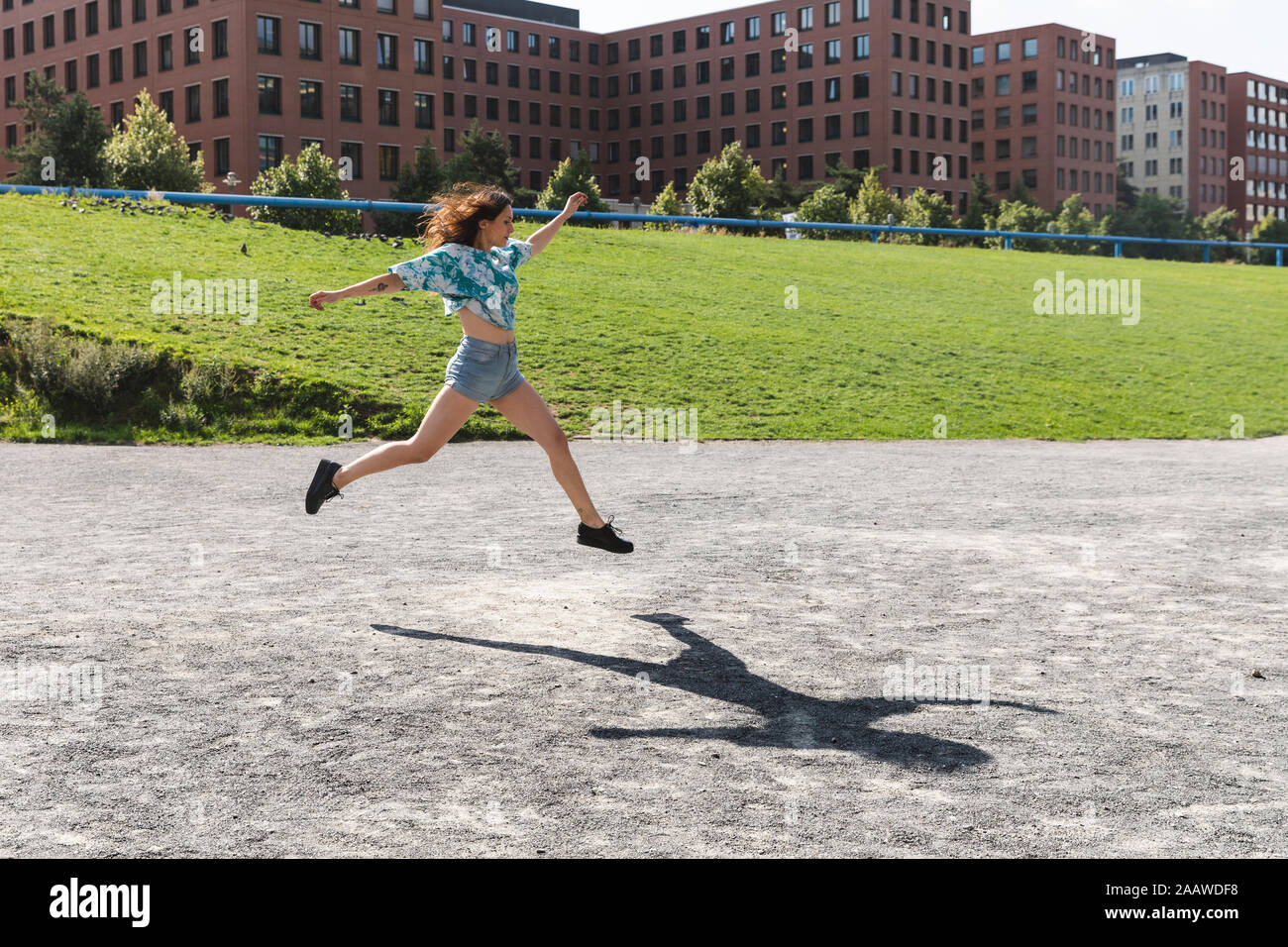 Junge Frau springen und laufen in der Stadt im Sommer Stockfoto