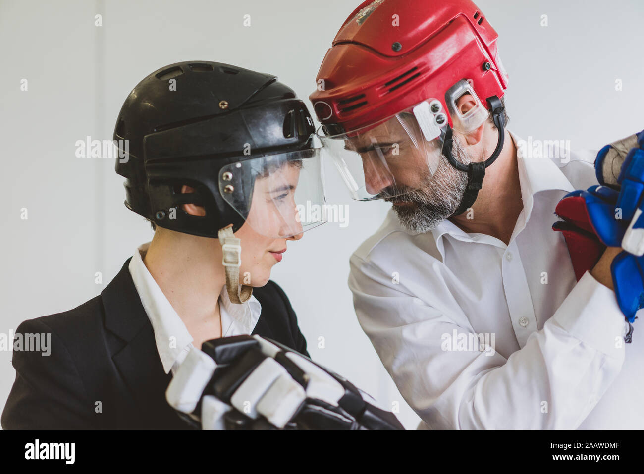 Unternehmerin und Unternehmer tragen Eishockey Ausrüstung im Büro Stockfoto