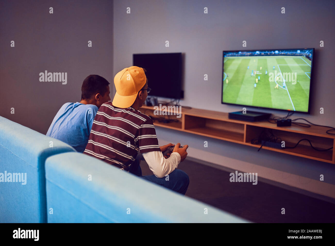 Teenage Freunde spielen video game in eine Spielhalle Stockfoto