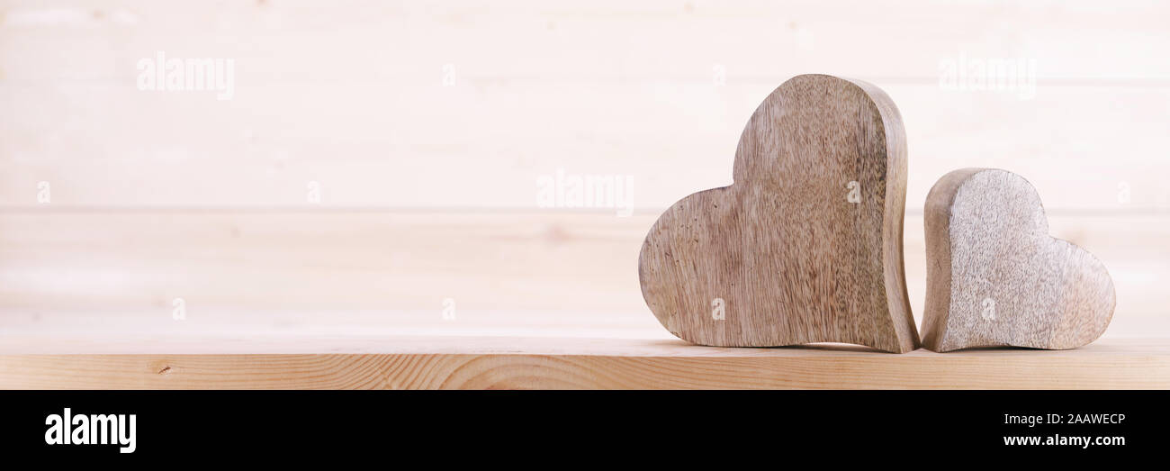 Zwei handgefertigt aus Holz geschnitzte Herz auf hellem Hintergrund paar Beziehung Valentinstag Konzept Stockfoto