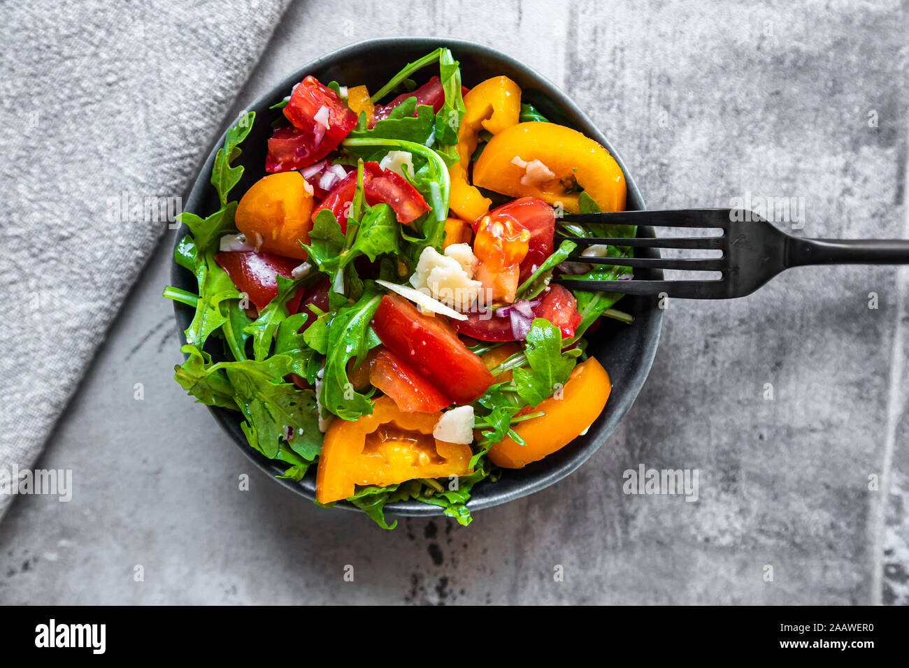 Schüssel Salat mit roten und gelben Tomaten, Rucola und Parmesan Stockfoto