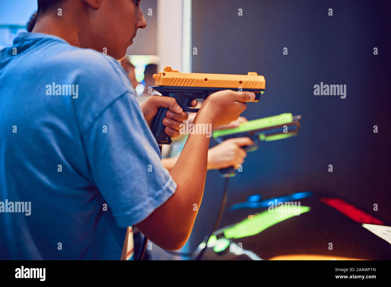Teenage Freunde schießen mit Pistolen in eine Spielhalle Stockfoto