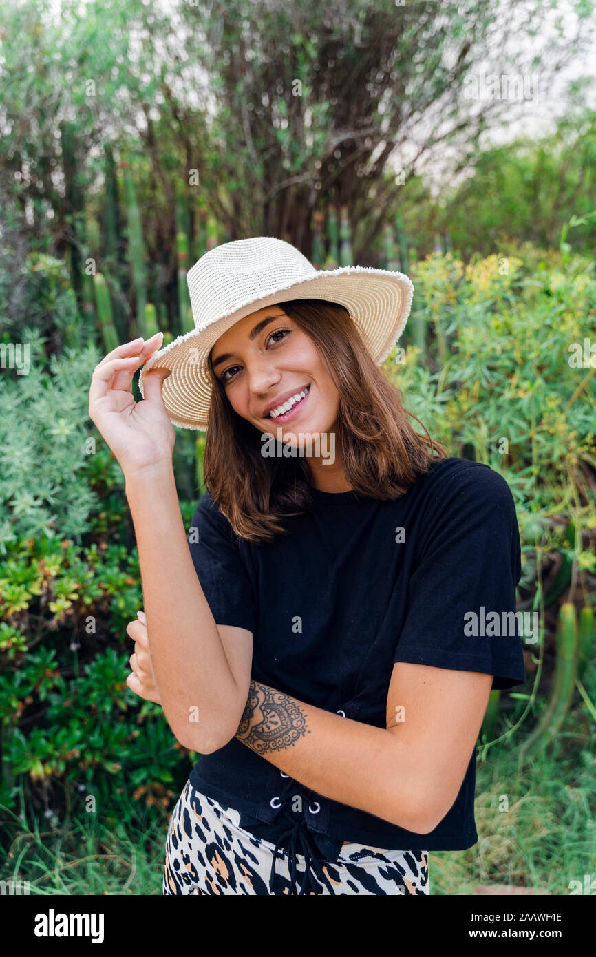 Portrait von lächelnden jungen Frau mit Tattoo tragen Sommer hat in der Natur Stockfoto