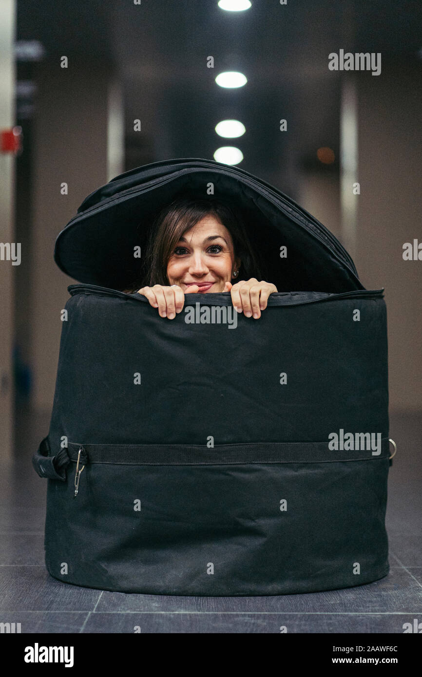 Lächelnde Frau versteckt in einer großen Tasche für Fässer Stockfoto