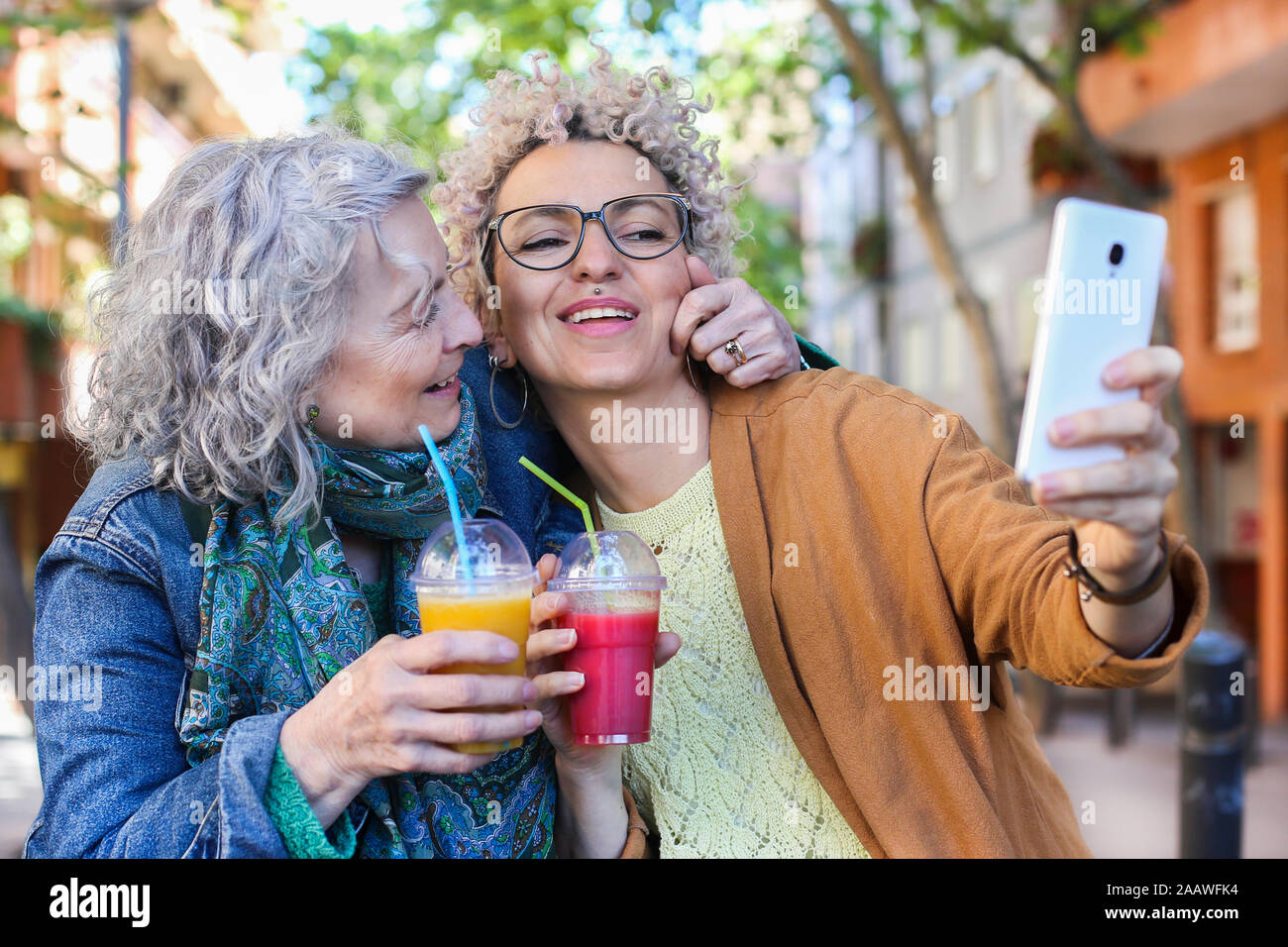 Ältere Mutter mit ihrer erwachsenen Tochter unter selfie in der Stadt Stockfoto